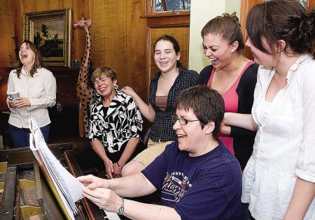 Rev. Paige Blair (far left) reacts during a sing-along presented to her by Holly Sargent, Taylor Palmer, Kelsey Ray, Sarah Palmer and pianist Kathy Fink. A farewell dinner was held at the Palmer-Sargent home Saturday evening.