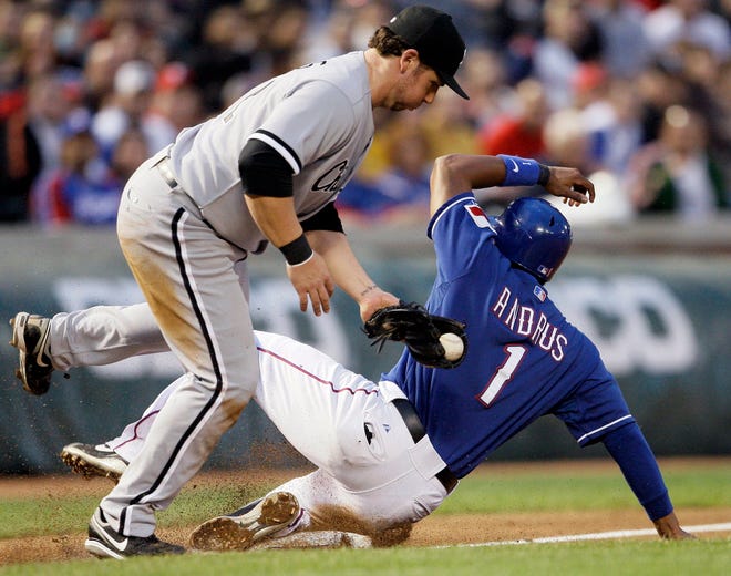 Texas Rangers' Elvis Andrus (left) steals third base as Chicago White Sox third baseman Josh Fields tries to make a tag in the third inning on May 3, 2009, in Arlington, Texas.