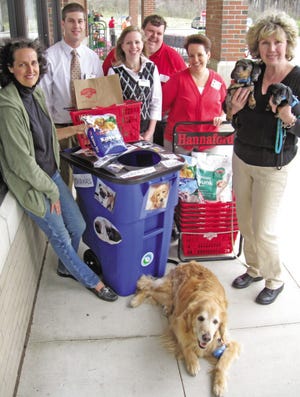 From left, Sally Manninen of A Healthy Maine Partnership, Evening Operations Manager Derek Veilleux, Assistant Store Manager Michelle Leczynski, Customer Service Clerk Matt Emhoff, Manager of Customer Service Sue Heald, animal advocate Jeannie Fazio, holding Spirit and Sage, and Joshua, 13, a Golden Retriever, promote the new pet food drop box at Hannaford in York, on Friday, May 1.