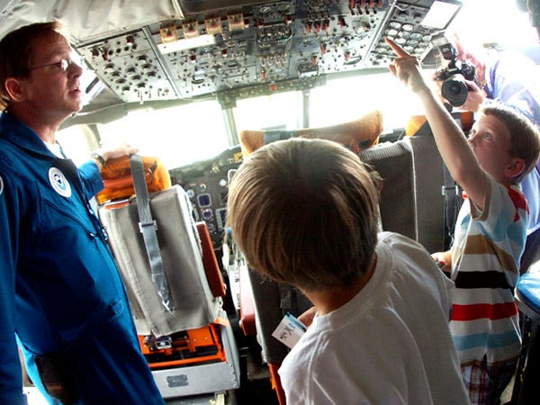 Electronics Technician Joe Bosko (left) gives students from area New Hanover County schools a tour of the cockpit aboard the U.S. Department of Commerce National Oceanic and Atmospheric Administration's (NOAA) Specialized WP-3D Orion aircraft. The aircraft is used to fly into hurricanes and gather information on the hurricane.