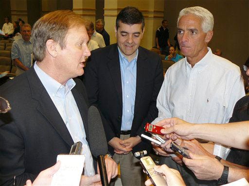Senate budget chairman J.D. Alexander, R-Winter Haven, left, talks to reporters about state spending compromises he struck with House budget chief David Rivera, R-Miami, center, as Gov. Charlie Crist, right, looks on after a session of House-Senate budget negotiations in Tallahassee, Fla., Sunday, May 3, 2009.