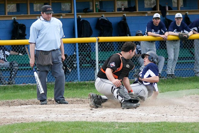 Umpire Brad Bosbous, left, keeps an eye on the play as Sault High’s Tyler Wollan is tagged out at home plate by Soo Black Sox catcher Spencer Howe during Thursday’s baseball game at James Field. The Blue Devils outlasted the Black Sox in a slugfest.