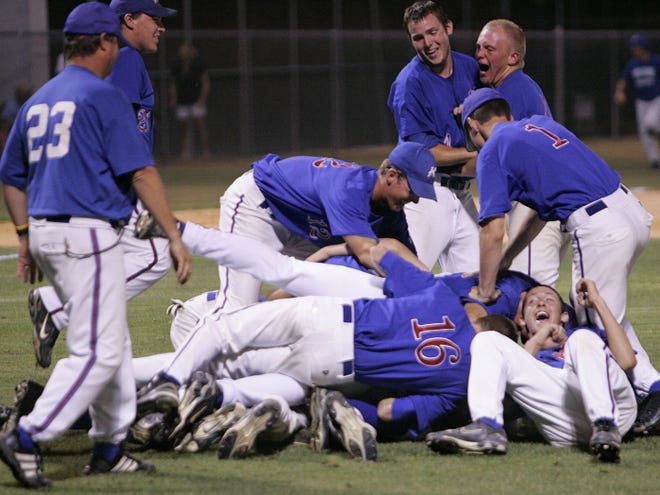 Keystone Heights team members form a dog pile over teammate Clayton Mosley, at bottom, in celebration of Mosley's game-winning run over Williston on Friday..