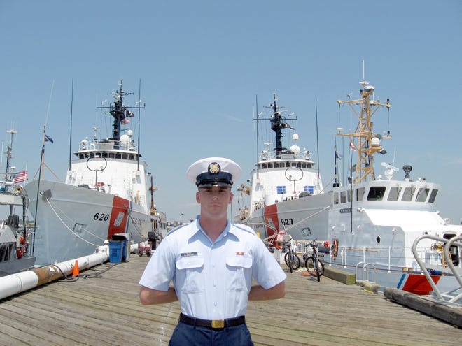 , Phil Kiley stands at parade rest in his Coast Guard uniform.