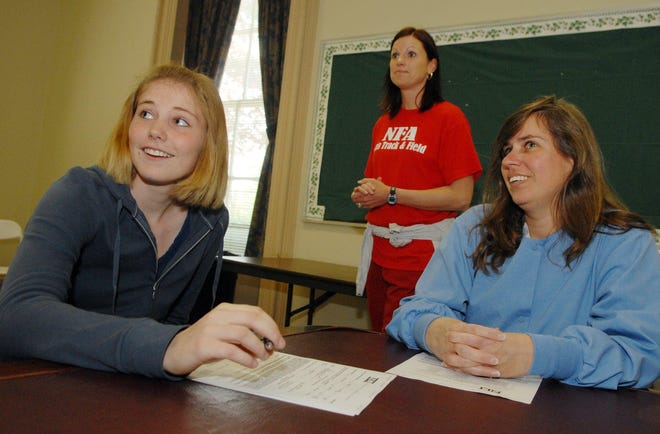Kim Johnson, left, Norwich Free Academy track and field stand out signs a national letter of intent with Southern Connecticut State University Friday, May 8, 2009 with her coach Kara Kochanski, center, and mother Kellie Johnson.