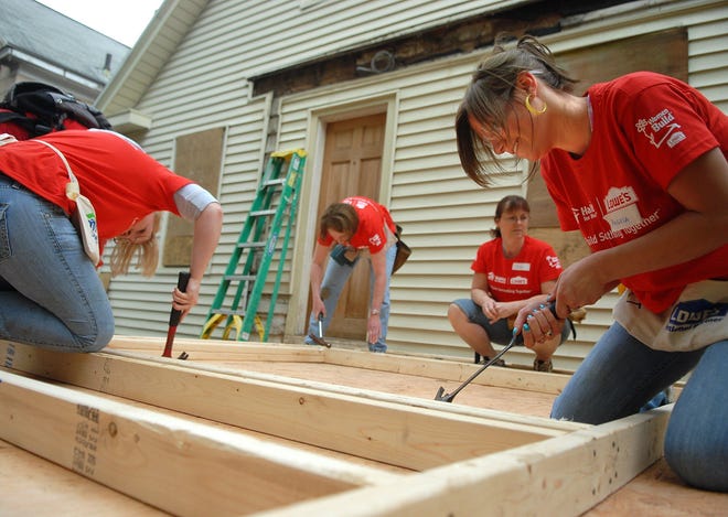 As part of Habitat for Humanity's National Women Build Week, Angela White of Dayville, right, and Kendra Bonnette of Woodstock, left, both Lowe's employees, work on a house in Putnam with Lisa Kilburn of Eastford, back left, a Habitat for Humanity volunteer and Bonnie Beland of Chaplin, back right, an architecture and construction teacher at Killingly High School.