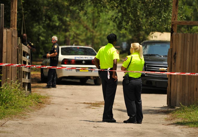 JON FLETCHER / The Times-UnionOfficers stand along perimeter tape on the driveway at 13201 Boney Road in northeast Jacksonville, FL, where two young girls were transported in critical condition after being pulled from a pond on the property