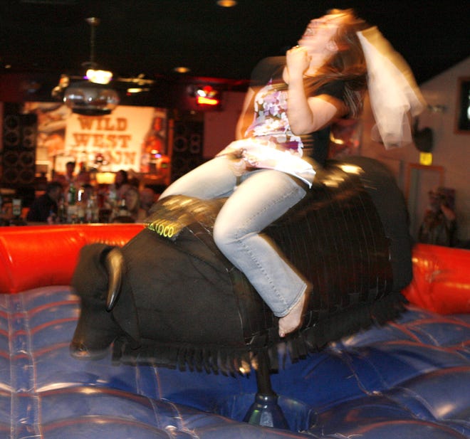 Molly Masters holds on as she rides the mechanical bull at Wild West Saloon in Canton.