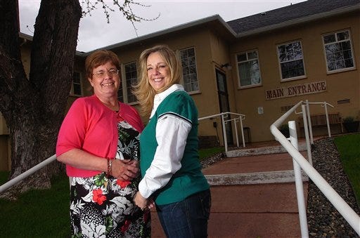 Kay Rene Qualls, left, of Heppner, Ore., and DeeAnn Shafer, of Richland, Wash., pose for a photo in front of the Pioneer Memorial Hospital in Heppner, Ore., May 6, 2009. They found out recently that they were switched shortly after being born 56 years ago.
