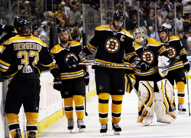 Boston Bruins players, from left, Patrice Bergeron (37), Chuck Kobasew, Zdeno Chara, and Tim Thomas leave the ice after they losing to the Carolina Hurricanes in Game 7 of an NHL Eastern Conference semifinal hockey playoff series in Boston Thursday, May 14, 2009. The Hurricanes won 3-2 in overtime. (AP Photo/Elise Amendola)