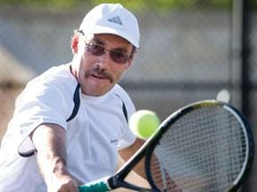 CHIEFTAIN PHOTO/BRYAN KELSEN — Bernie Fay of La Veta concentrates on a backhand return Thursday at the Paper Cup Tennis Tournament at the City Park Tennis Complex. He defeated Allen Drummond 6-1, 6-4 in the men's 4.0 singles division.