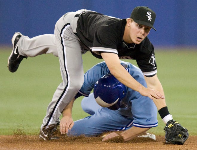 Chicago White Sox second baseman Chris Getz, top, tumbles over Toronto Blue Jays' Aaron Hill as he turns a double play during the first inning Friday in Toronto. Jays' Vernon Wells was out at first.