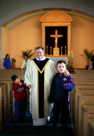 The Rev. John Carmichael and Colin McKenna,10, and John Nee,8, practice leaving the altar in procession at a rehearsal for Sunday's First Communion service at St. Ann's By The Sea Church.