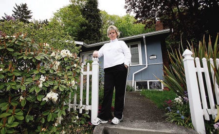 Rose Inman stands on the walkway at the home she is about to lose in Seattle. Inman has been laid off twice and can no longer afford her $3,100 monthly mortgage payments and hasn't had any luck getting her mortgage bill lowered.
