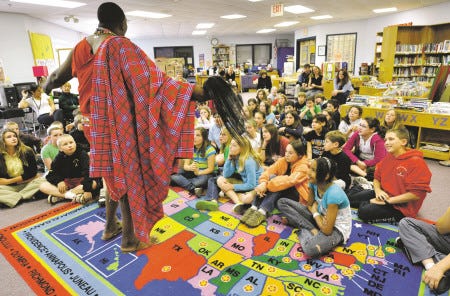 Ledama Olekina, a member of the Maasai in Kenya, talks to students at Rye Elementary School on Monday. The school is collecting books to send to Africa. Olekina is working to build 210 libraries, one in each of Kenya's districts, and he needs 2.1 million books.