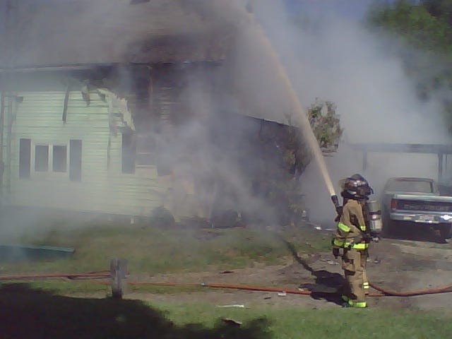 Canton firefighters fight a blaze in a house on Alexander Place NE near Cherry Avenue NE this afternoon.