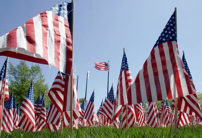Free flags for people to place on the graves of veterans sit Wednesday, May 20, 2009, in front of the Field of Honor in Loves Park.