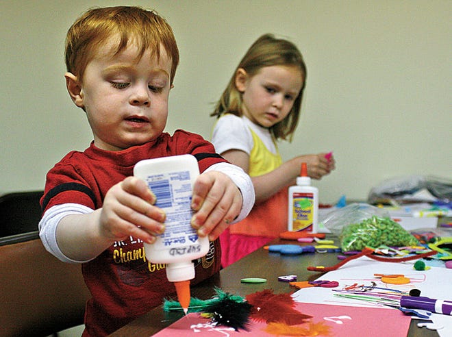 Brody Baker, age 2, squeezes some more glue onto his art project as Taylor Pratt, 5, looks up from her own craft to watch. The two were attending the Infant/Toddler Playgroup at Algonquin Methodist Church in Sault Ste. Marie on Tuesday. Playtime starts at 10 a.m. each week.