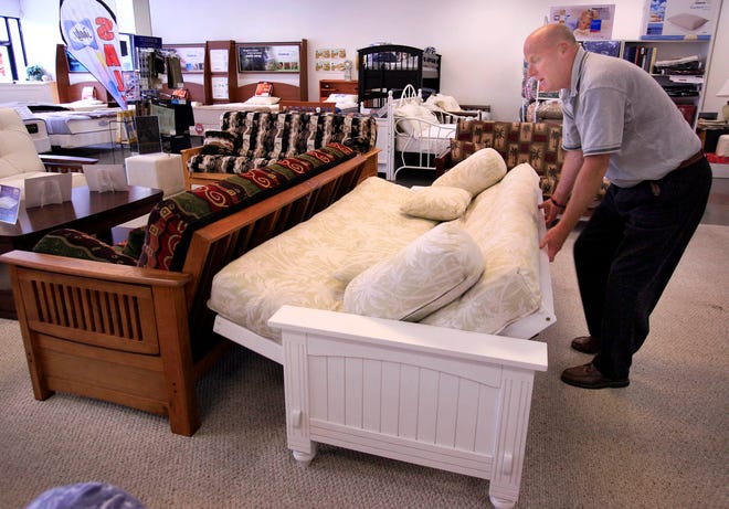 Steve Wilde, manager of Mattress and Futon King in Weymouth, opens a futon.