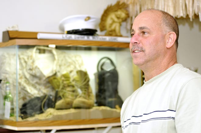Mark McVicker recalls fond memories of his oldest son, Daniel, a 2003 graduate of West Branch High School. The family could not bear to put Daniel's boots and fatigues away after his death, so they created a lighted shadow box of mementos.