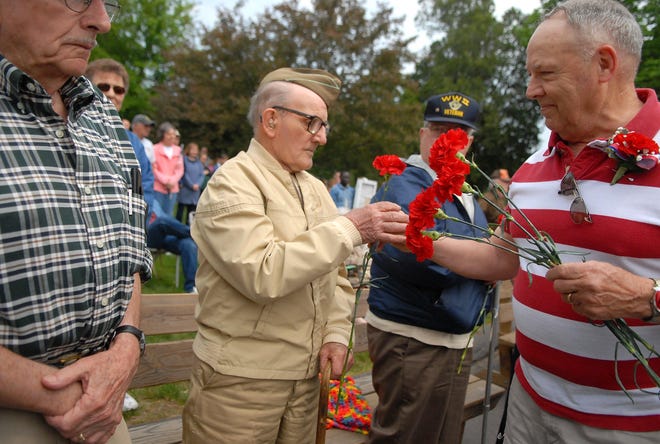 World War II veteran Joseph Brisson of Lebanon, accepts a red carnation from Lebanon Selectman Russell Blakeslee, right, during a ceremony to honor veterans following the Lebanon Memorial Day Parade Saturday, May 23, 2009. Later in the Memorial Day ceremony, outside Lebanon Town Hall, Blakeslee was named the 2009 Citizen of the Year.
Tali Greener/Norwich Bulletin