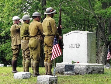 Photo by Elisa D. Keller/New Jersey Herald
 Area residents in World War I infantryman uniforms salute the commemorative headstone of Charles A. Meyer at Andover Borough Cemetery. The Newton American Legion Post 86 was founded in Meyer’s honor after his death in World War I.
