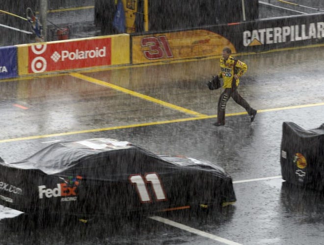 A member of Kyle Busch's pit crew runs for cover as a heavy downpour hits before the Coca Cola 600 NASCAR Sprint Cup series auto race at Lowe's Motor Speedway in Concord, N.C., Sunday, May 24, 2009.