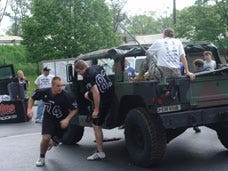THE RACE IS ON Jackson High School’s Nick Sobevski (#74) and Matt Cochran (#83) jump out of the Army Humvee to race to the other side. Also, on the team, but not pictured, were Max Dehnke and Joel Sweitzer.