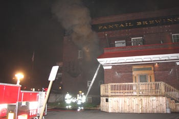 Heavy smoke comes from an upstairs window of Fantail Brewing Company as Sturgis firefighters work to extinguish the fire in the basement.