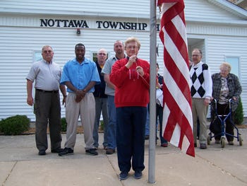 Mendon resident Bernice Metzger gets ready to raise the flag that once draped her husband’s casket. The May 18 ceremony during the Nottawa Township board meeting commemorated Metzger giving the flag to Nottawa Township to fly outside its business office in downtown Centreville.