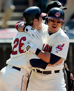 Cleveland Indians' Shin-Soo Choo (right) hugs teammate Trevor Crowe after he scored on a single by Jhonny Peralta in the ninth inning against the New York Yankees on Sunday. The Indians won 5-4.