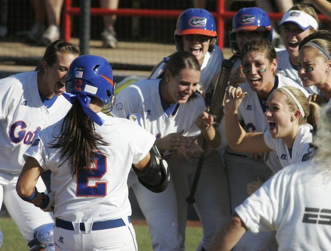 Florida's Kelsey Bruder (2) is greeted at the plate by her teammates after hitting a home run against Alabama in the fourth inning of an NCAA softball championship tournament game in Oklahoma City, Sunday. Florida won the game 6-5, eliminating Alabama from the tournament.