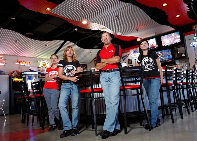 Hostess Morgan Schwaub, left, waitress Andrai Voight, general manager Jeff Neuzil and bar manager Bobbi Flournoy are part of the team at Bogey's Restaurant & Sports Pub, which opened a second restaurant in Bradenton. The original Bogey's opened in Venice in 1998.STAFF PHOTO / THOMAS BENDER
