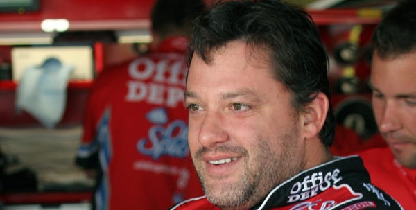 Tony Stewart climbs into his car in the garage area before practicing for the NASCAR Autism Speaks 400 on May 30.