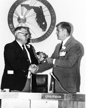 Tommy Needham, left, turns the gavel over to the new Marion County Commission chairman, Steve Gilman, in 1988. Needham died May 9.