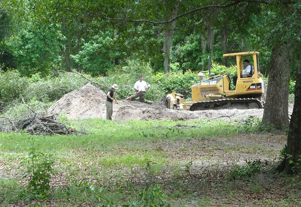 Law enforcement officials use a bulldozer to search for a reported homicide victim from 28 years ago in Clay County recently.