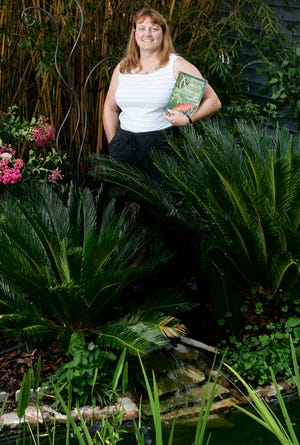 Sandy Saurers stands amongst her Florida-friendly yard that feature native and heat resistant plants outside Saurers' Newberry home on Thursday, June 4, 2009.