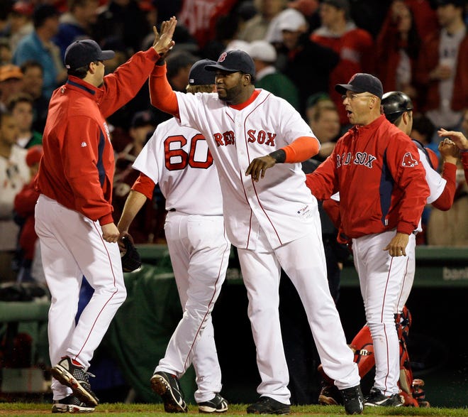 David Ortiz, center, high-fives starting pitcher Josh Beckett as manager Terry Francona, right, celebrates with players after the Red Sox' 7-0 victory over the Yankees on Tuesday night at Fenway Park.