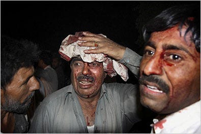Wounded men after a bombing on Tuesday outside a five-star hotel in Peshawar, Pakistan.