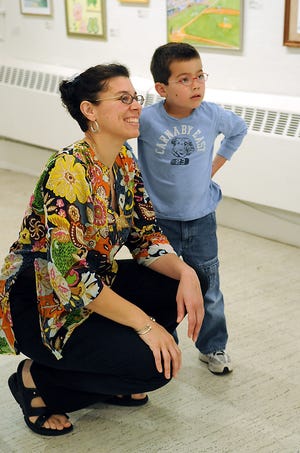 New Art Center Director of Exhibitions and Community Partnerships Ceci Mendez talks with student artist Christopher Milan, 6, of Newton, about his artwork in the exhibit.