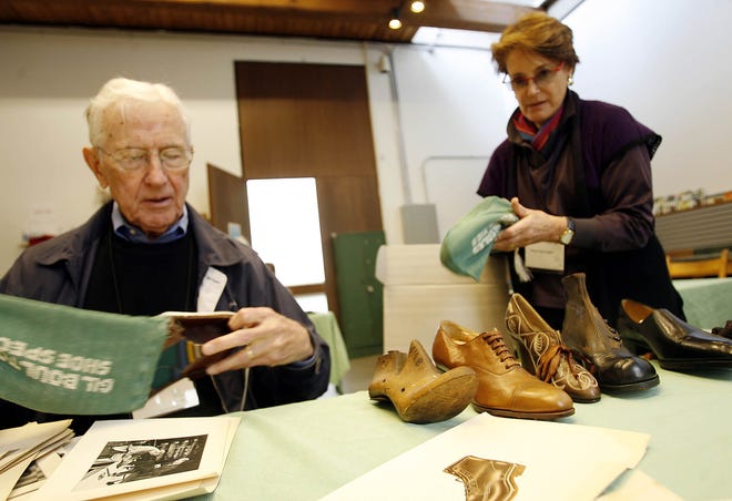 The shoe exhibit at the Fuller Craft Museum has been in the making since last year. In this October photo, John Learnard, chairman of the Brockton Shoe Museum Committee, looks through antique shows as he and guest curator Wendy Tarlow Kaplan prepare for the exhibit “The Perfect Fit — Shoes Tell Stories.”