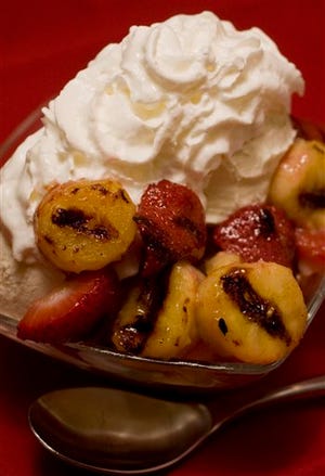 This photo shows Grilled Strawberries and Bananas with Ice Cream. Keep the grill going after the burgers are done and impress all with a grilled dessert. These Grilled Strawberries and Bananas with Ice Cream just may be the most memorable part of the days barbecue. (AP Photo/Larry Crowe)