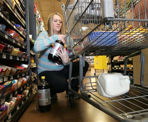 In this March 24, 2009 photo, Brooke Zupnick of Gahanna, Ohio, unloads her grocery cart near the LaneHawk loss prevention device at Kroger store in Gahanna, Ohio. Stores are employing new measures, both seen and unseen, to fight back against rising theft problems during the recession. While retailers won't give away all their security secrets, industry officials say stores are adding plainclothes patrols on their floors and that increasingly sophisticated video surveillance systems, some that allow a security expert to monitor stores across the country, are becoming common.