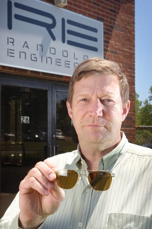 Randolph Engineering CEO Peter Waszkiewicz holds a hair of his company's sunglasses.