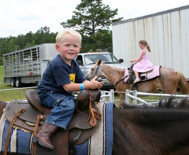 KEVIN TURNER/StaffHunter Cooner, 3, of Hilliard, takes a ride on a horse during the 2007 Northeast Florida Fair Blueberry Festival. This year's festival begins Friday at the fairgrounds near Callahan.
