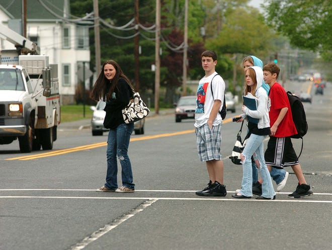 Wary teenagers in Whitman wait for traffic to allow them to cross Temple Street (Route 27) recently. Several cars passed before one finally stopped.