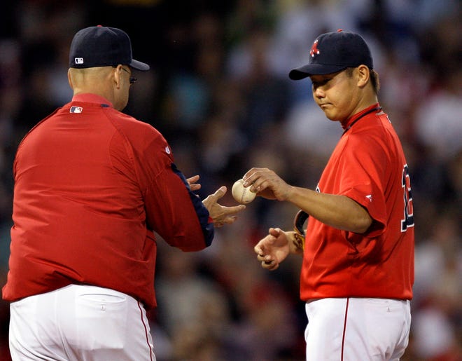 Red Sox starting pitcher Daisuke Matsuzaka hands the ball to manager Terry Francona as he is removed in the fifth inning of their baseball game against the Atlanta Braves at Fenway Park in Boston Friday, June 19, 2009. (AP Photo/Elise Amendola)