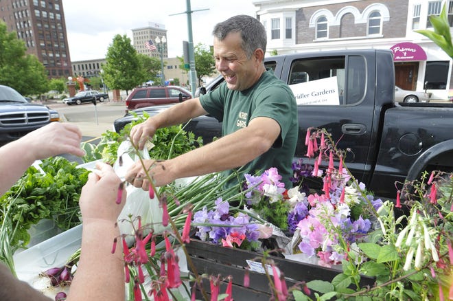 Barry Kridler of Homeworth works from his booth at the Downtown Canton Farmers' Market Saturday.