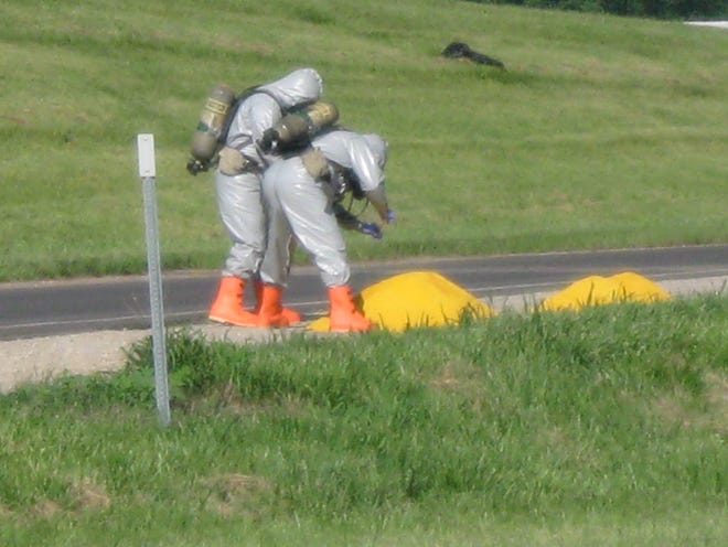 Topeka Fire Department personnel, some wearing full hazmat suits, were investigating two piles of yellow powder at the westbound entrance ramp to US-24 from Goodyear.