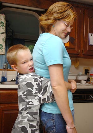 Tyler Healy, 7, demonstrates the Heimlich maneuver, which he used on his mother Dawn when she was choking on an egg roll on Monday.